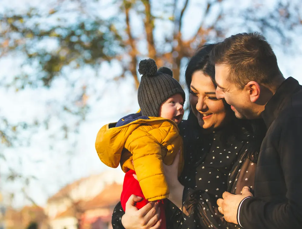 Two adults and a child outdoors in natural light